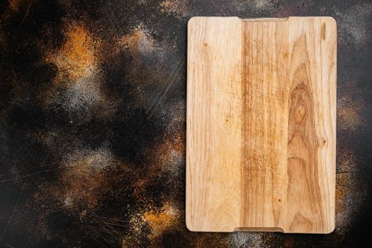 Pine wooden cutting board, on old dark rustic table background, top view flat lay , with copy space for text or your product