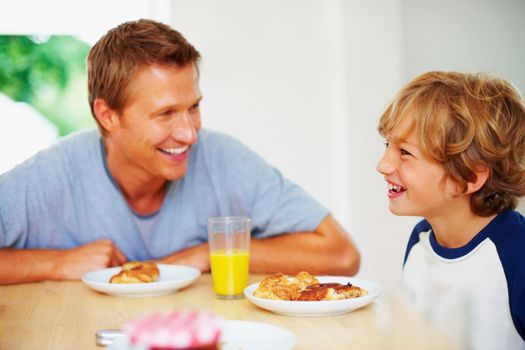 Portrait of a cheerful father and son together having breakfast.