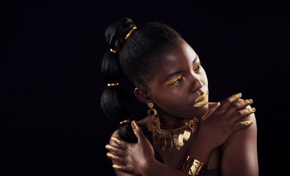 Can black get more beautiful. Studio shot of a beautiful young woman wearing make up and jewellery against a black background.