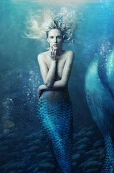 Shot of a mermaid swimming in solitude in the deep blue sea - ALL design on this image is created from scratch by Yuri Arcurs team of professionals for this particular photo shoot