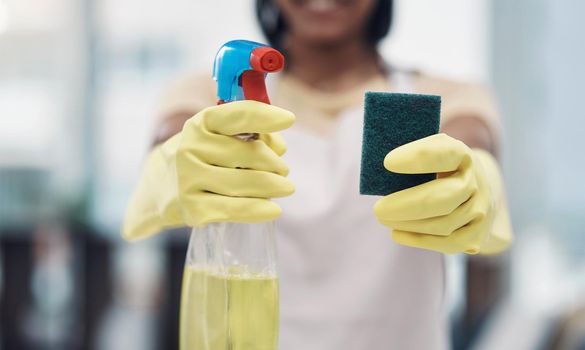 All you need in your bacteria busting arsenal. Shot of an unrecognisable woman using rubber gloves and disinfectant to clean her home.