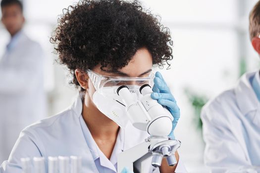 female scientist in protective clothing works in a scientific laboratory.