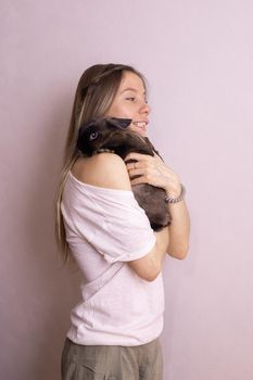Young woman with adorable rabbit indoors, close up. Lovely pet and animal concept