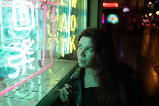 Cinematic night portrait of girl and neon lights in city with copy space - night life and youth concept