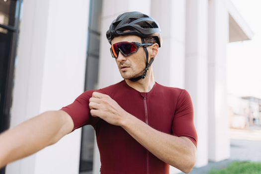 Sportsman in activewear preparing cycling on city streets