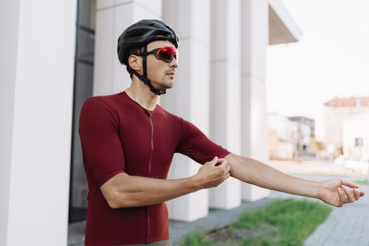 Caucasian cyclist adjusting his sport clothes before workout