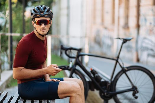 Sporty man in activewear using smartphone after cycling