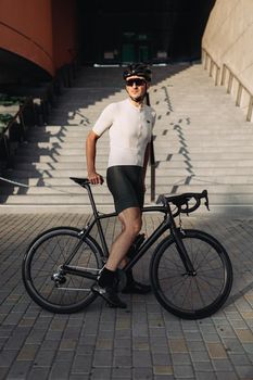 Caucasian cyclist standing with sport bike at urban area