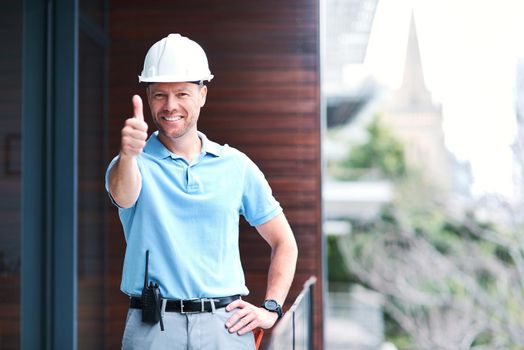 Were all set to get going. Portrait of a cheerful engineer posing with his thumbs up outside a building.
