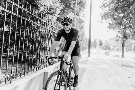 Monochrome photo of active cyclist ride bike on city street