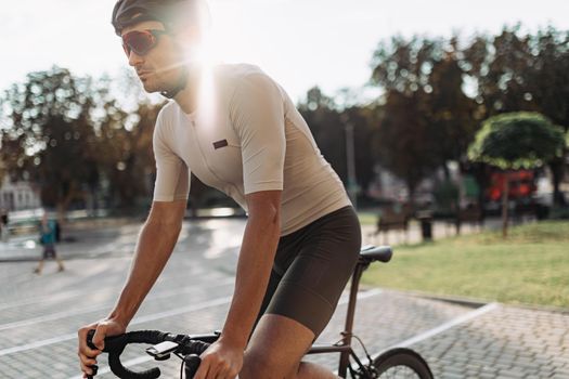 Male athlete doing cardio on bike during sunny day