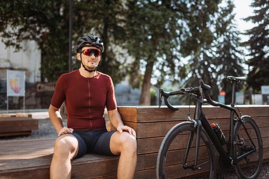 Caucasian cyclist resting after workout on bench