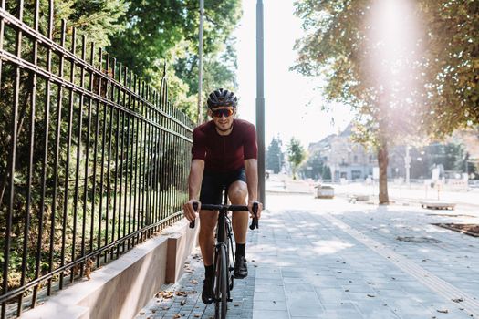 Happy cyclist in sportswear riding bike on city street