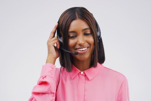Shes a dedicated customer service representative. Studio shot of an attractive young female customer service representative wearing a headset against a grey background.