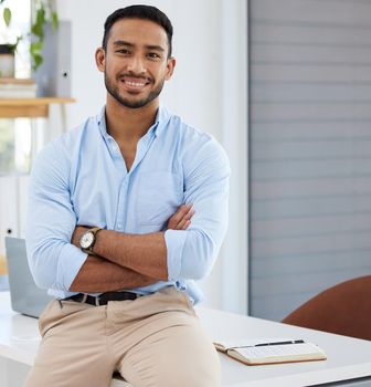 There are many rewards waiting at the end of hard work. Portrait of a confident young businessman standing with his arms crossed in an office.