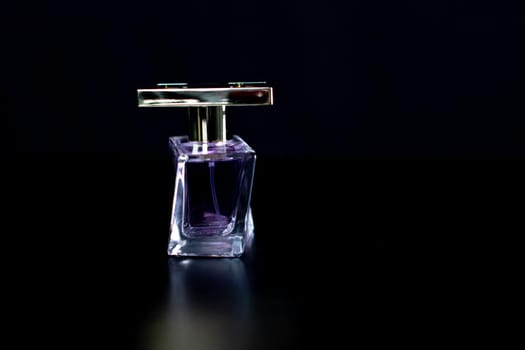 Elegant perfume bottle isolated on black background with copy space.