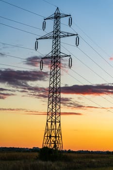 Detail of electric pole with electric cables at sunset