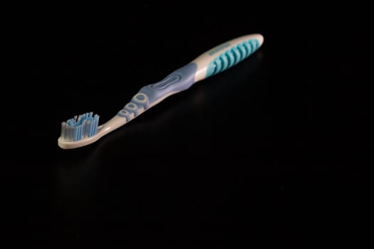 Selective focus on toothbrush isolated on black background.