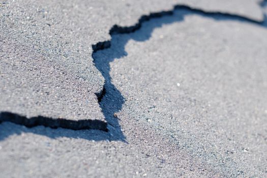 A crack in the pavement on the road. The concept of bad roads