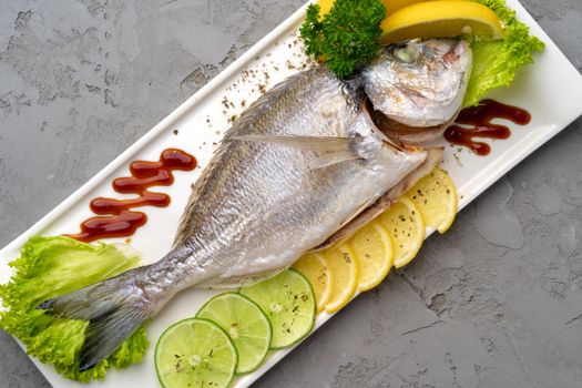 Fresh sea fish with lemon on plate