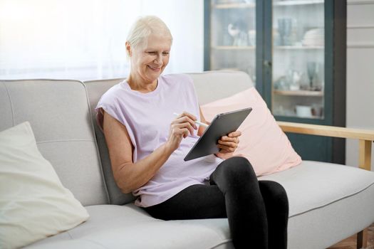 elderly woman sitting in a yoga pose in front of an open laptop.