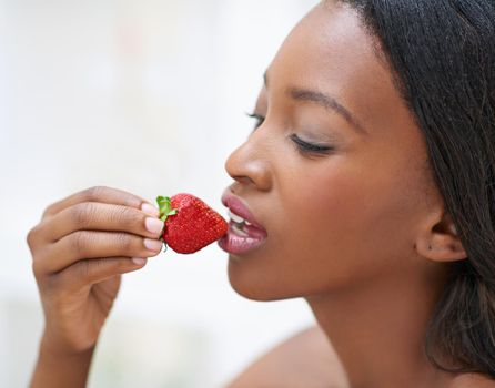 The forbidden fruit. Shot of a beautiful young woman eating strawberries.