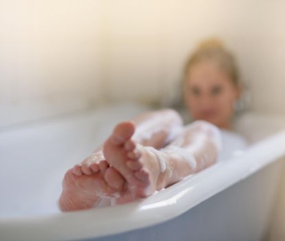 Let all your worries just drift away. Shot of a beautiful young woman relaxing in the bathtub.