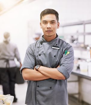 I make only the best dishes. Cropped portrait of a young male chef standing with his arms folded in the kitchen.