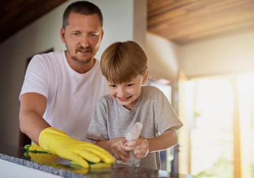 Lets get this household clean. Shot of a father and his little son doing chores together at home.