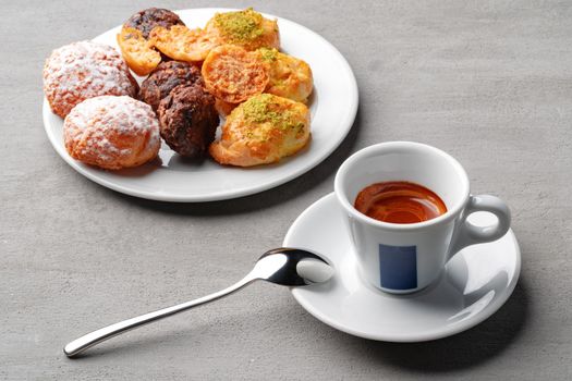 Cup of espresso and cookies on a gray table