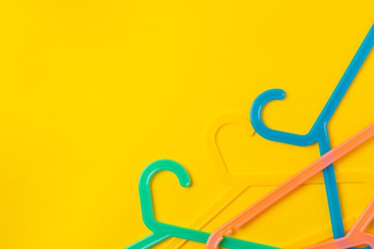Hanger on colored paper background. Minimalistic fashion concept.