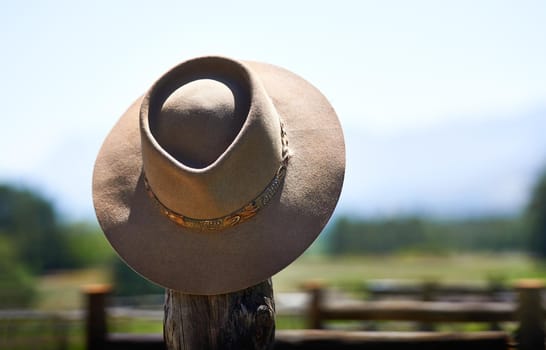 Hats off to you. Shot of a wide brimmed hat on a fence post.