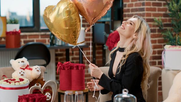 Attractive smiling woman enjoying romantic surprise with balloons