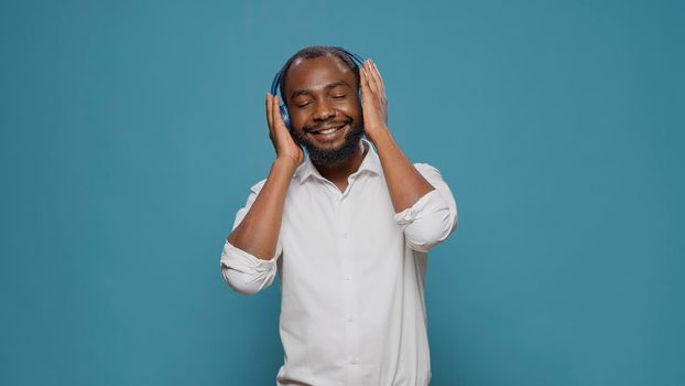 Smiling adult using headphones to listen to mp3 radio music