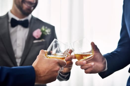 My buddies are welcoming me into the married life. Shot of two unrecognizable groomsmen sharing a toast with the bridegroom on his wedding day.