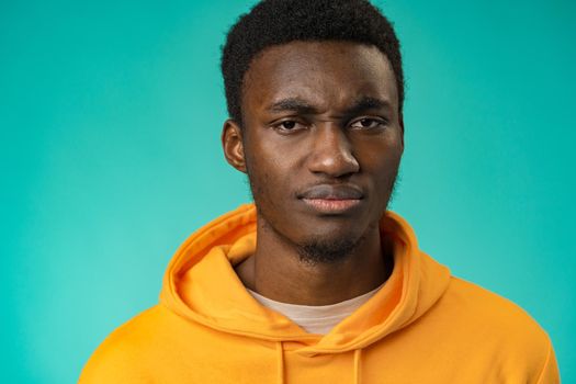 Portrait of young handsome afro-american guy sadly looking at camera in studio