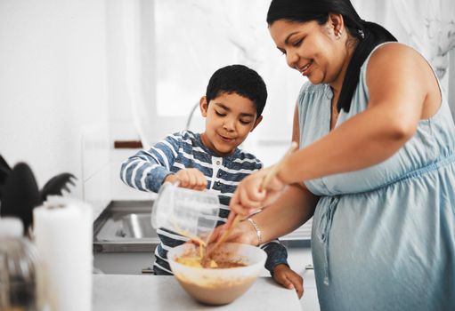 Shot of a mother and her little son baking together at home.