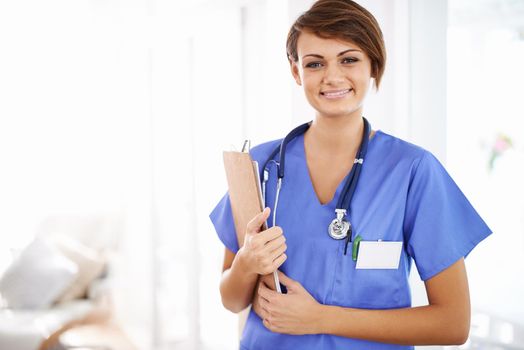 Shell nurse you back to health. Portrait of an attractive young doctor in scrubs holding a clipboard.