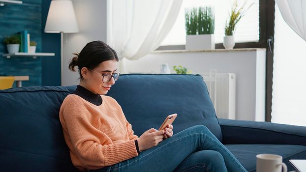 College student browsing internet on smartphone at home