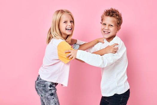 funny children hug casual clothes pink background