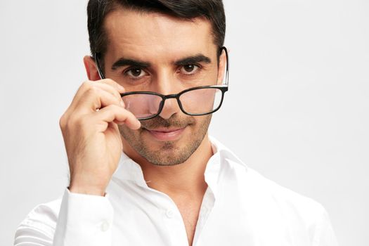 smart businessman with glasses in white shirts puts on glasses copy-space light background