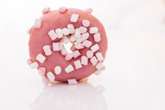 Assortment of donuts of different flavors. Pink glazed marshmallow donut. Bright and colorful sprinkled donut on a white background