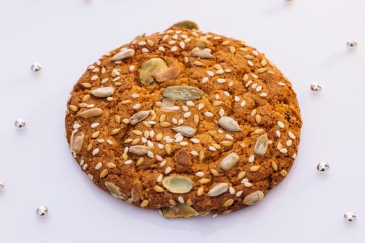 Eat oatmeal cookies. Stack of whole meal cookies on white background. Wheat fall on dietary cookies.