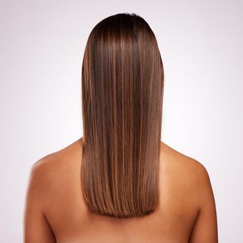Perfectly layered. Studio shot of an unrecognizable young woman standing with her back facing the camera to show off her hair against a grey background.
