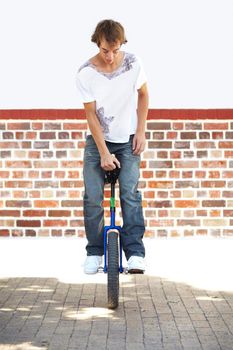 Hes got skill. Full-length shot of a young man balancing on a unicycle.