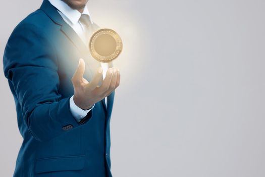 Its not magic, its encrypted money. Studio shot of a businessman holding a bitcoin against a grey background.