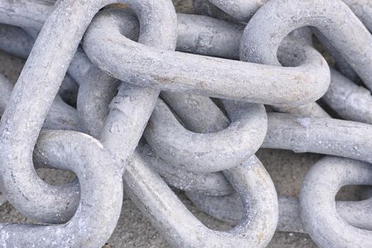 Made of metal. A cropped closeup image of a linked chain.
