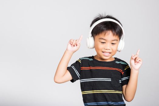 Little cute kid boy 5-6 years old listen music in wireless headphones