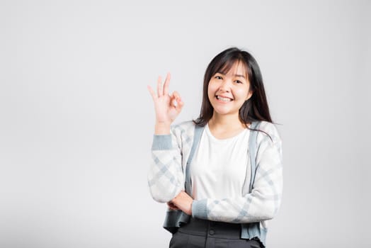 Woman smiling showing made finger OK symbol sign to agree
