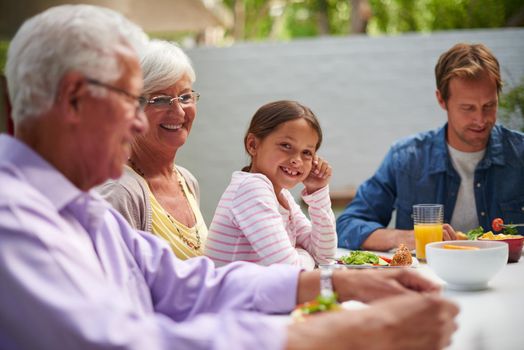 Fun-filled family lunch. Shot of a happy multi-generational family having a meal together outside.